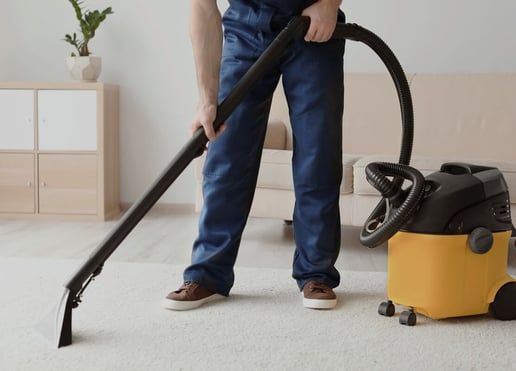 nass_trockensauger-mann_saugt_teppich_im_wohnzimmer